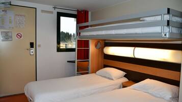 A room with two beds, a window, a door, and a wall-mounted shelf.