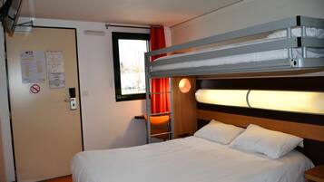 Una habitación de hotel con una cama litera, un escritorio y una silla.
