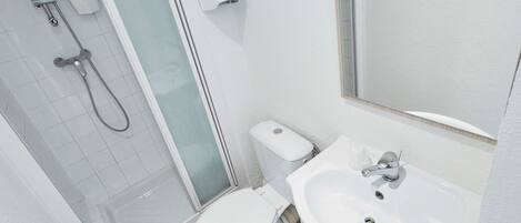 A bathroom with a shower, toilet, and sink.