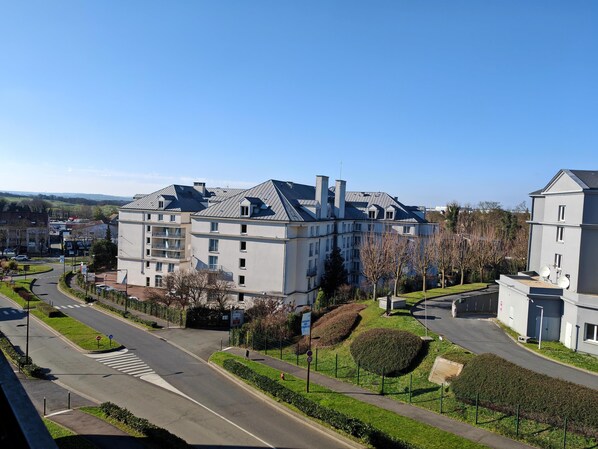 A multi-story residential building with a modern design, featuring a central courtyard and a well-maintained lawn. - Première Classe Roissy - Aéroport Charles De Gaulle (Roissy-en-France)