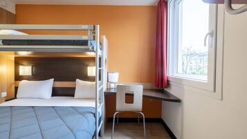 A bunk bed room with a desk and chair, a window with curtains, and a view of buildings outside.