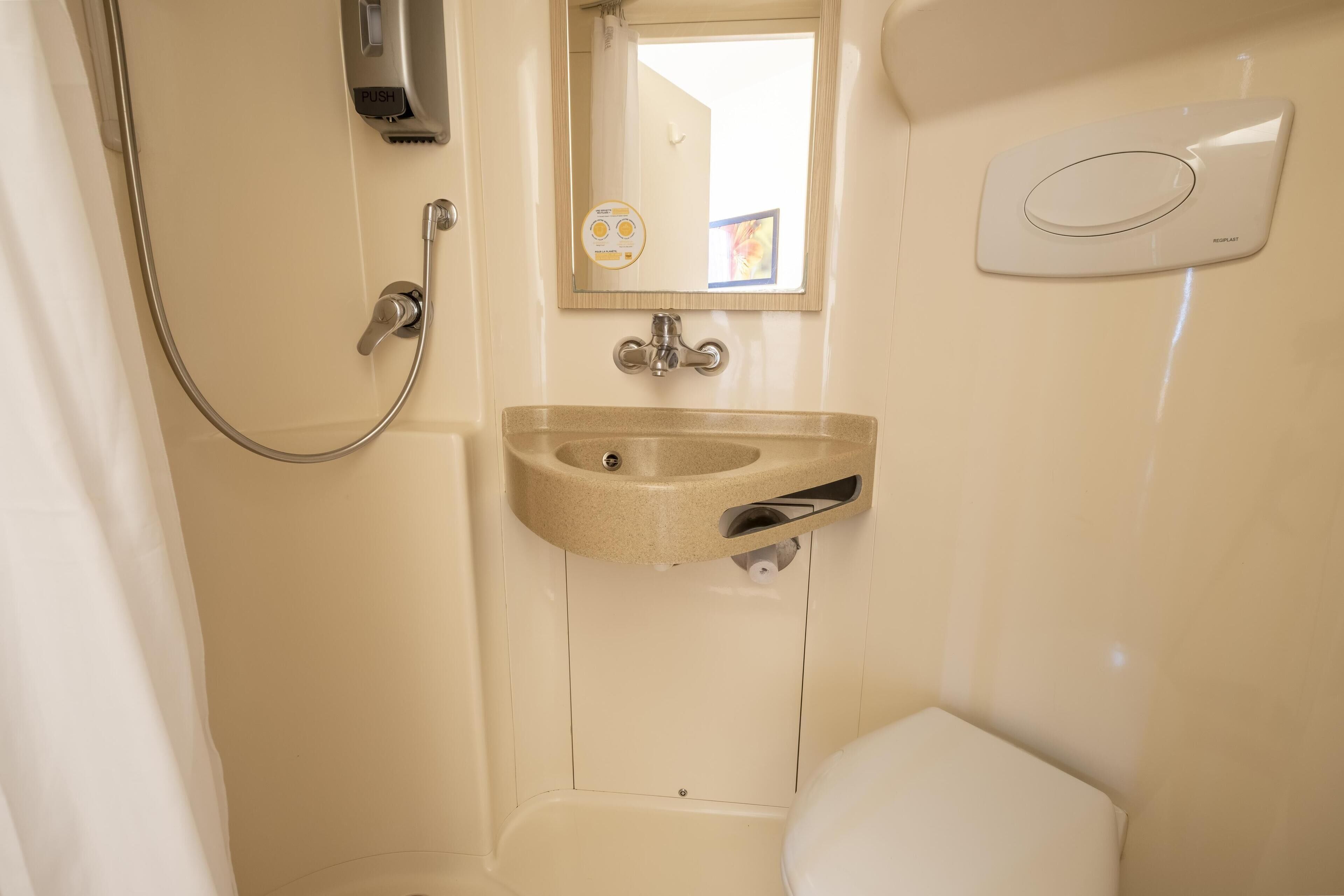 A bathroom with a shower, sink, and toilet.