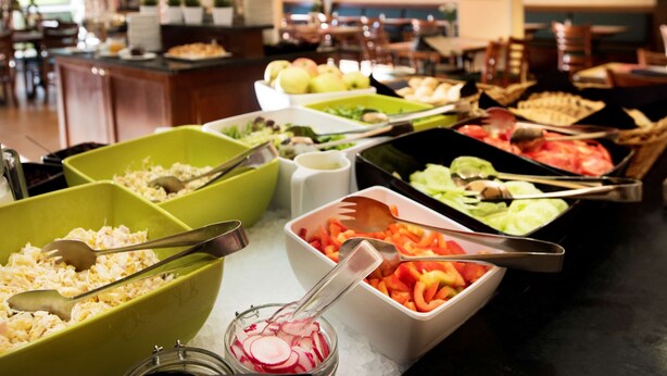 A buffet with various food items and serving utensils.