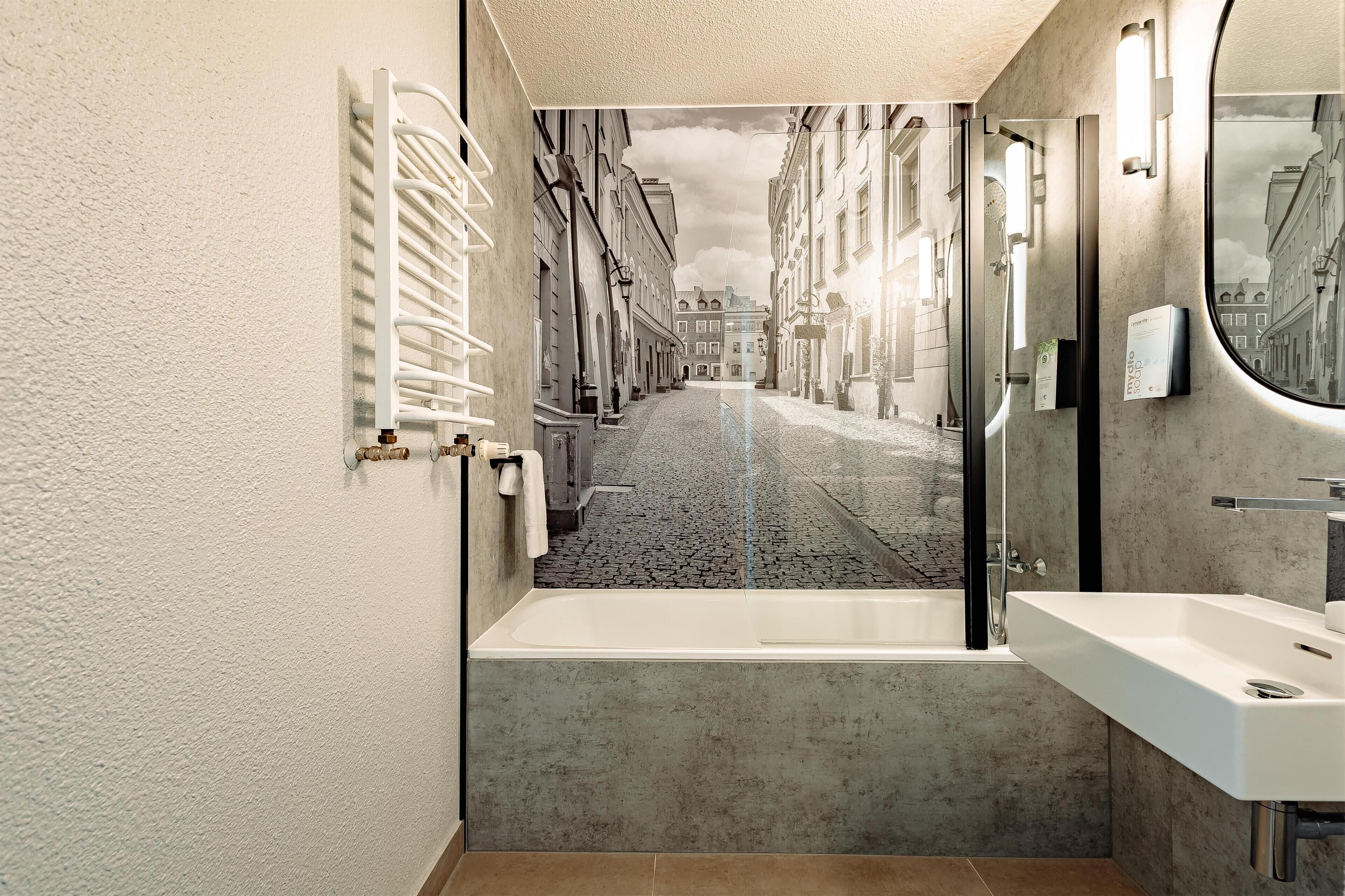 Une salle de bain avec une baignoire, un lavabo et un miroir.