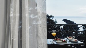 Un balcón con una mesa dispuesta para el desayuno, con vistas a un paisaje marino.