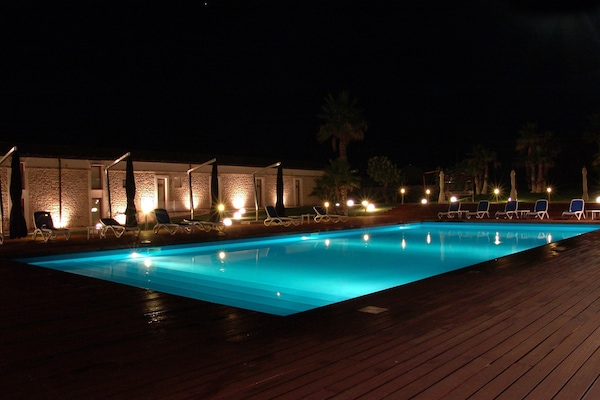 Alberca al aire libre y camastros