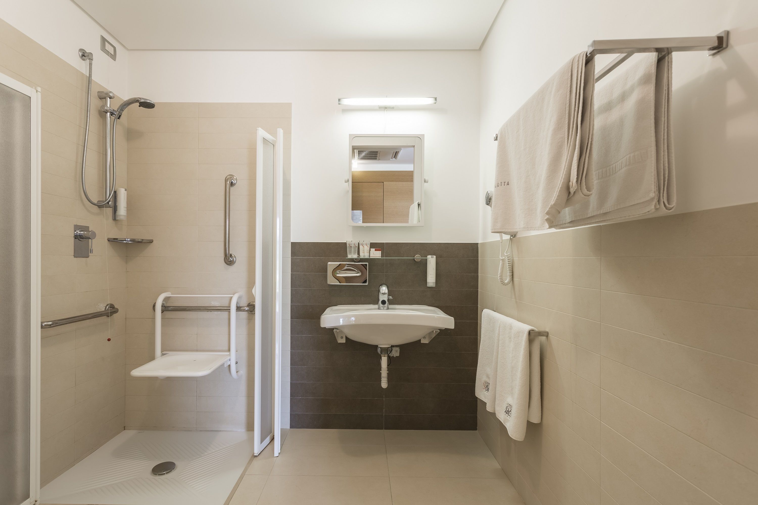 A modern bathroom with a shower, a sink, and a toilet.