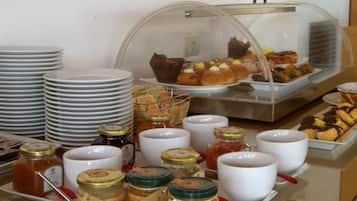 Ein reichhaltiges Buffet mit verschiedenen Speisen, Tellern und Gewürzbehältern.