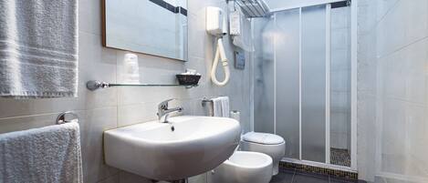 A modern bathroom with a sink, toilet, and shower.