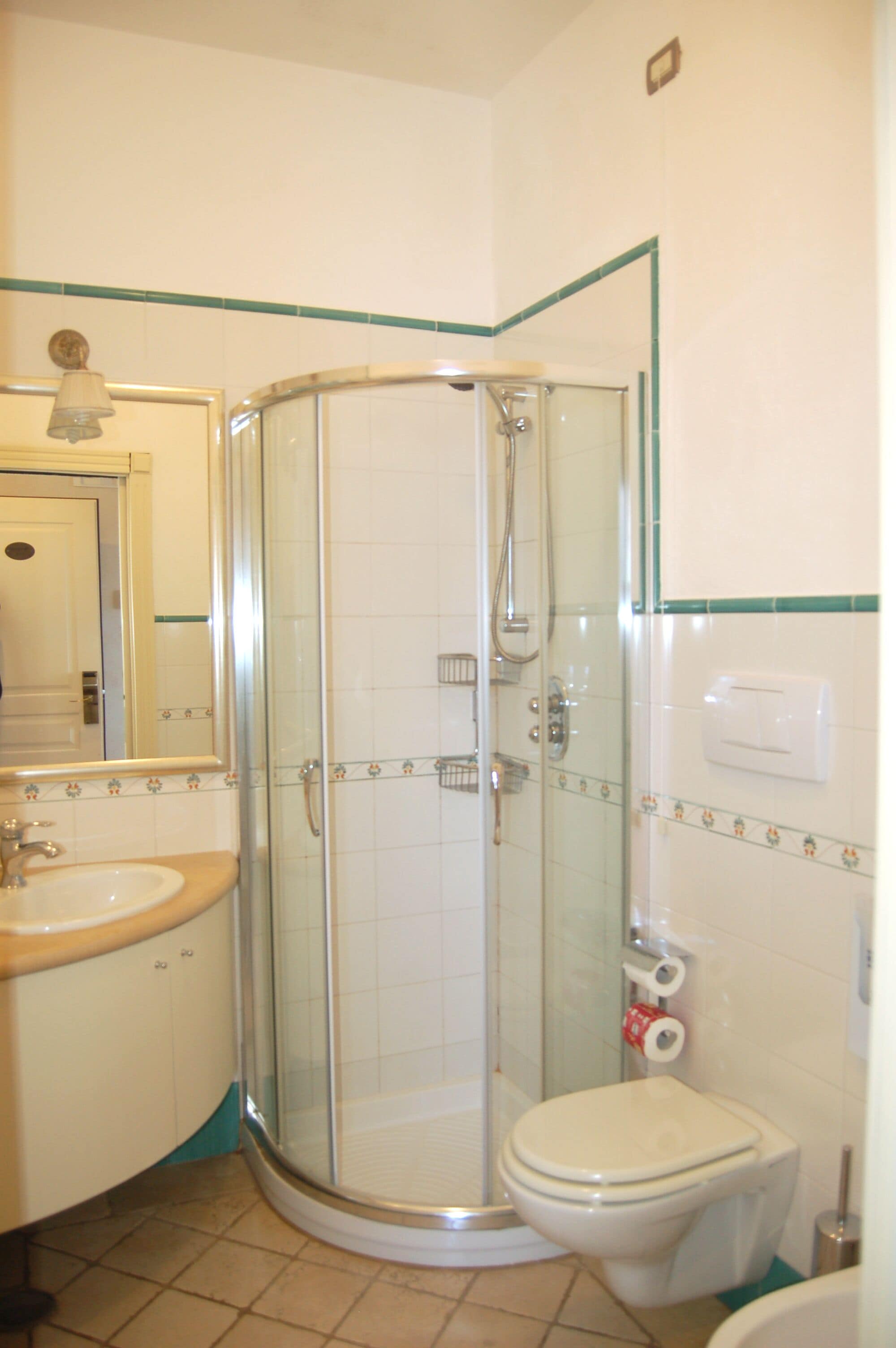 Une salle de bain avec une douche à parois de verre, des toilettes et un lavabo.