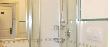 Une salle de bain avec une douche à parois de verre, des toilettes et un lavabo.