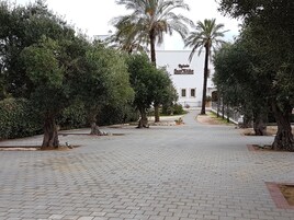 A paved pathway leading to a building with a sign reading "Regal Sant'Elige."