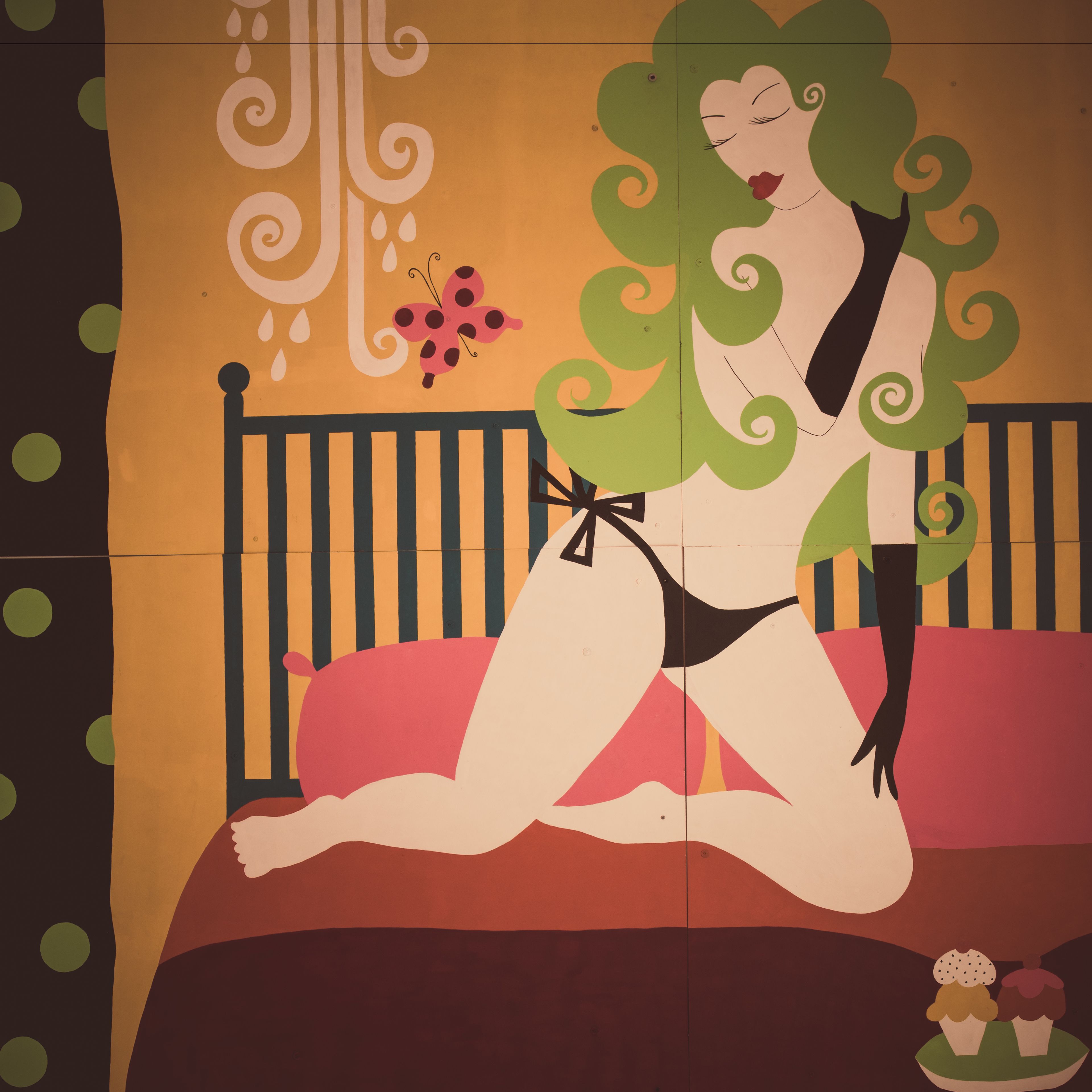 A stylized illustration of a person sitting on a bed with a striped headboard.