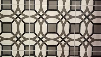 Pared de azulejos con un diseño geométrico repetido.