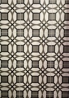 Pared de azulejos con un diseño geométrico repetido.