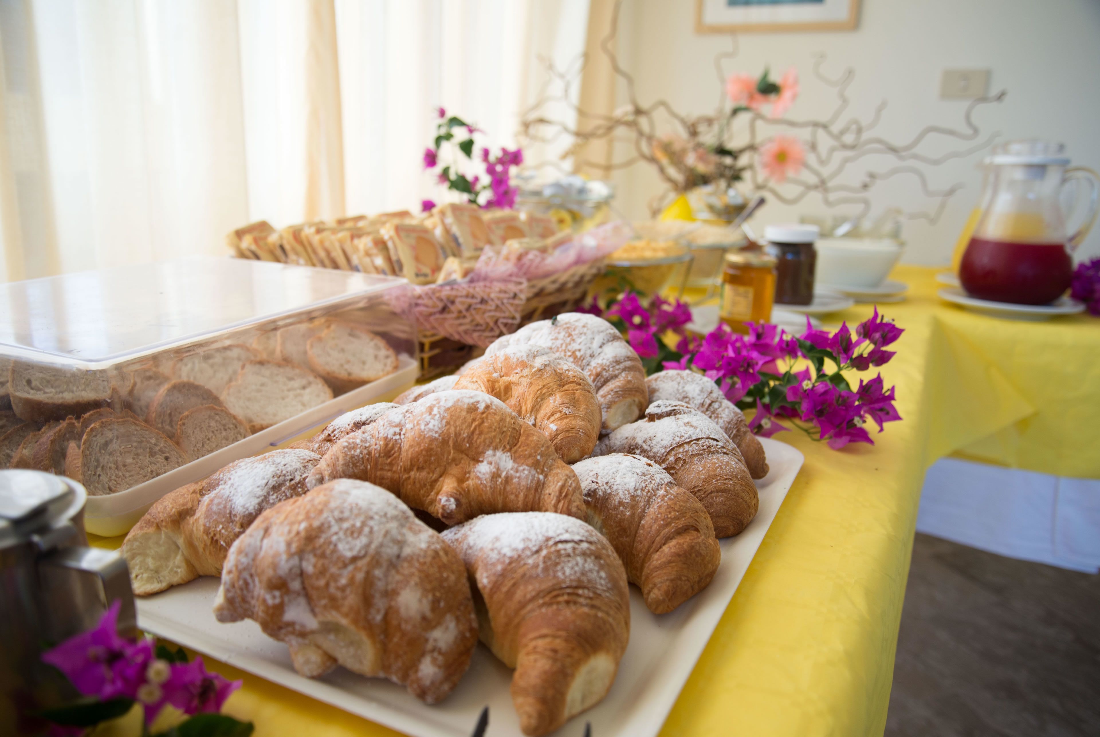 A table with pastries and a coffee pot.