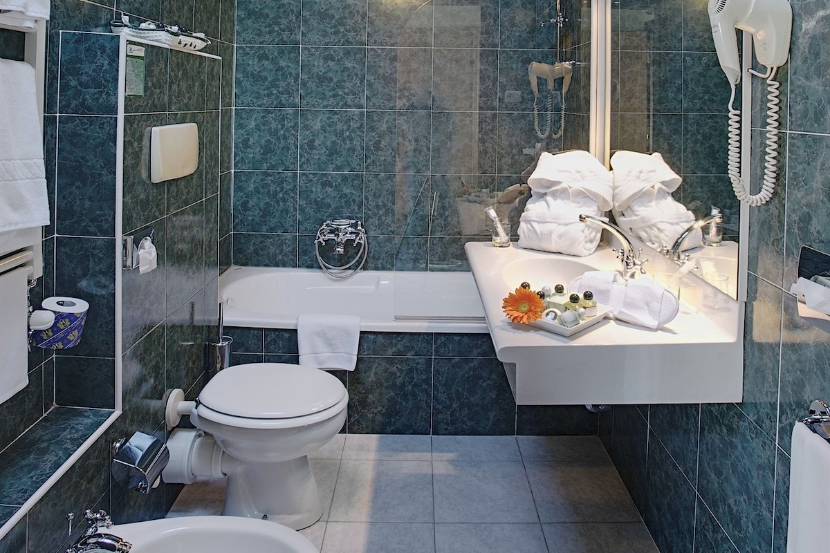 Un baño moderno con bidé, inodoro, lavabo y ducha de bidé.