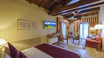 Une chambre d’hôtel avec un grand lit, un bureau, une chaise, un canapé et un téléviseur.