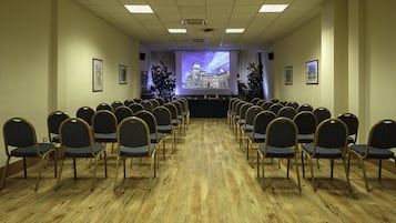 A conference room with rows of chairs facing a projection screen.
