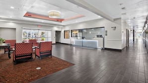 A hotel lobby with a reception desk, seating area, and an exit sign. - Sonesta Essential Hotel Houston-I-45 Spring (Houston)