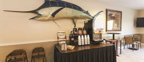 Un área de bar con una gran decoración de pescado, una estación de café y asientos.