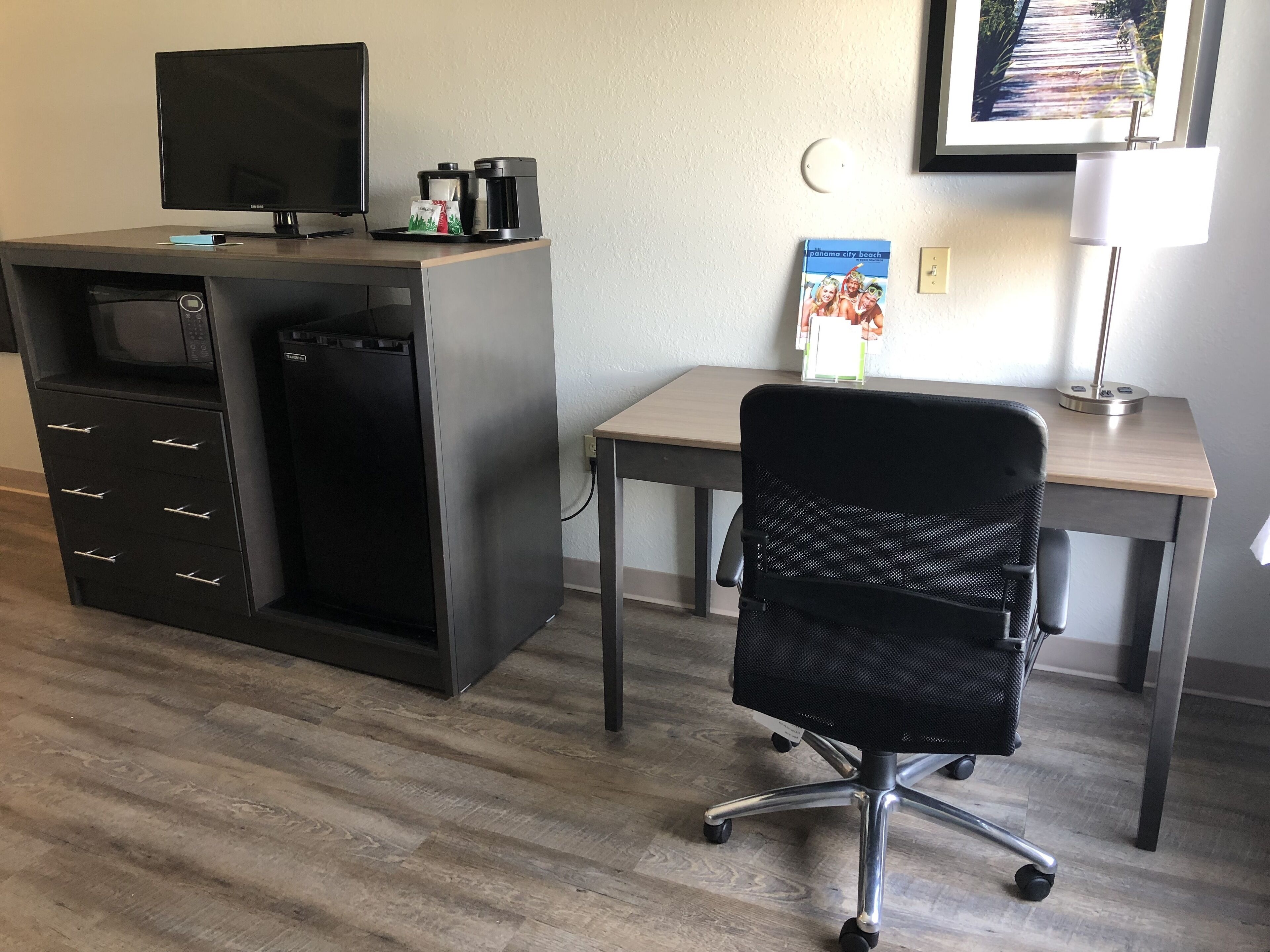 Un espace de bureau moderne comprenant un bureau, une chaise et des appareils intégrés.