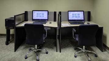 A cubicle office with two desks, each with a computer and a keyboard.