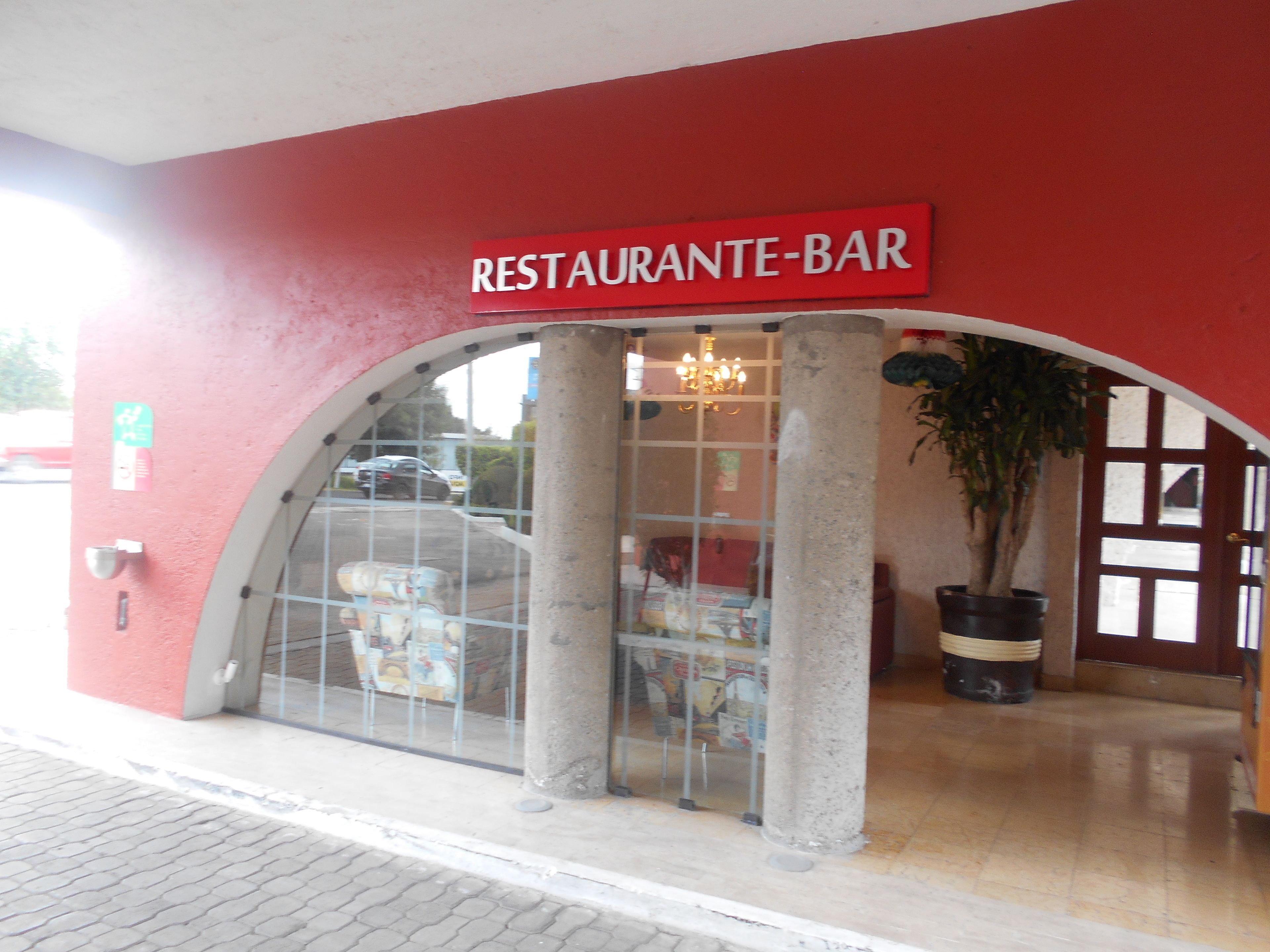 Un restaurante con fachada roja y un letrero que dice "RESTAURANTE-BAR".