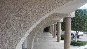 Un pasillo con una serie de columnas y suelo de baldosas.