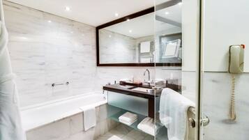 A modern bathroom with a glass-enclosed shower, a bathtub, and a vanity with a mirror.