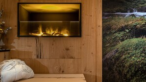 A wooden interior with a fireplace, a bench, and a wall-mounted shelf. - Hotel Rosa degli Angeli (Pejo)