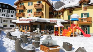 A hotel with a restaurant and outdoor seating area covered in snow. - Hotel Rosa degli Angeli (Pejo)