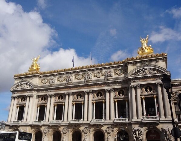 A grand building with classical architecture, featuring columns, statues, and ornate decorations.