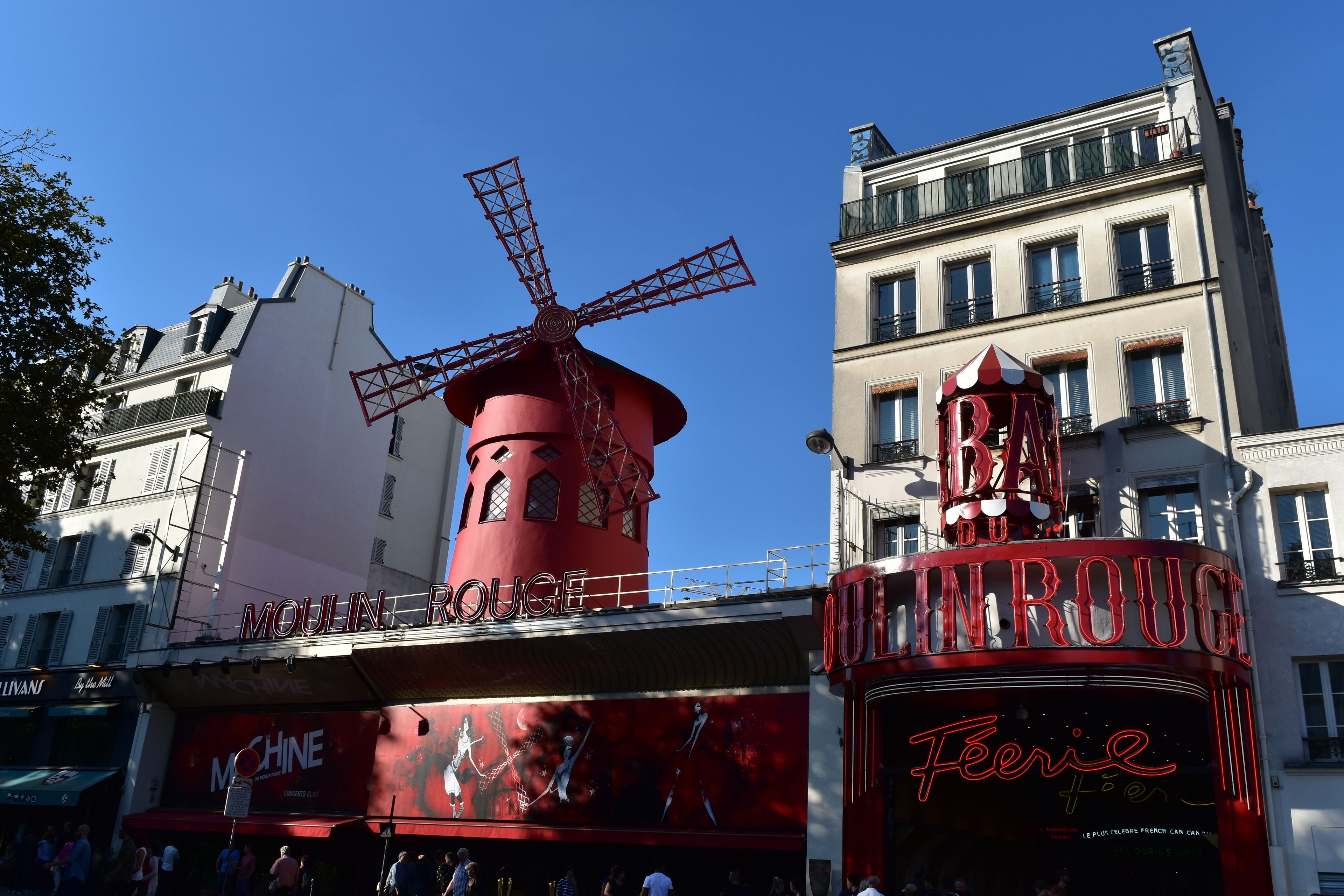 A red windmill and a building with a sign reading "Moulin Rouge".