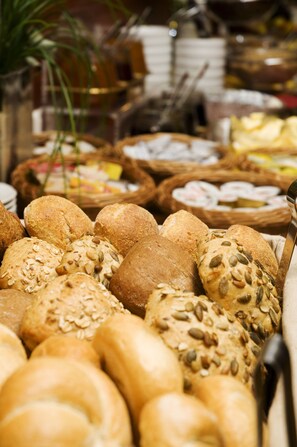 Variedad de panes y pasteles expuestos en cestas.