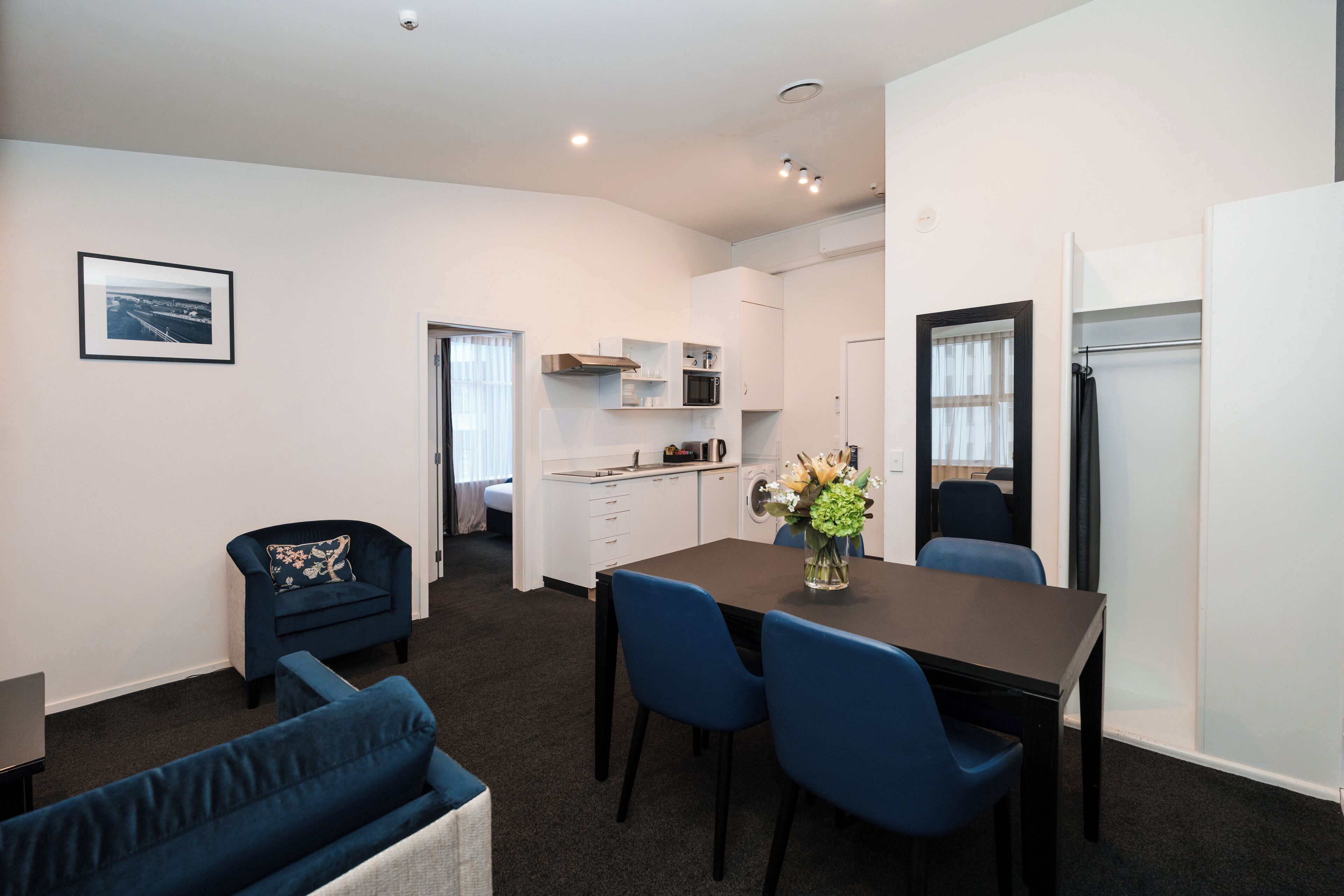Un espace de vie compact comprenant un coin repas, une kitchenette et un canapé.