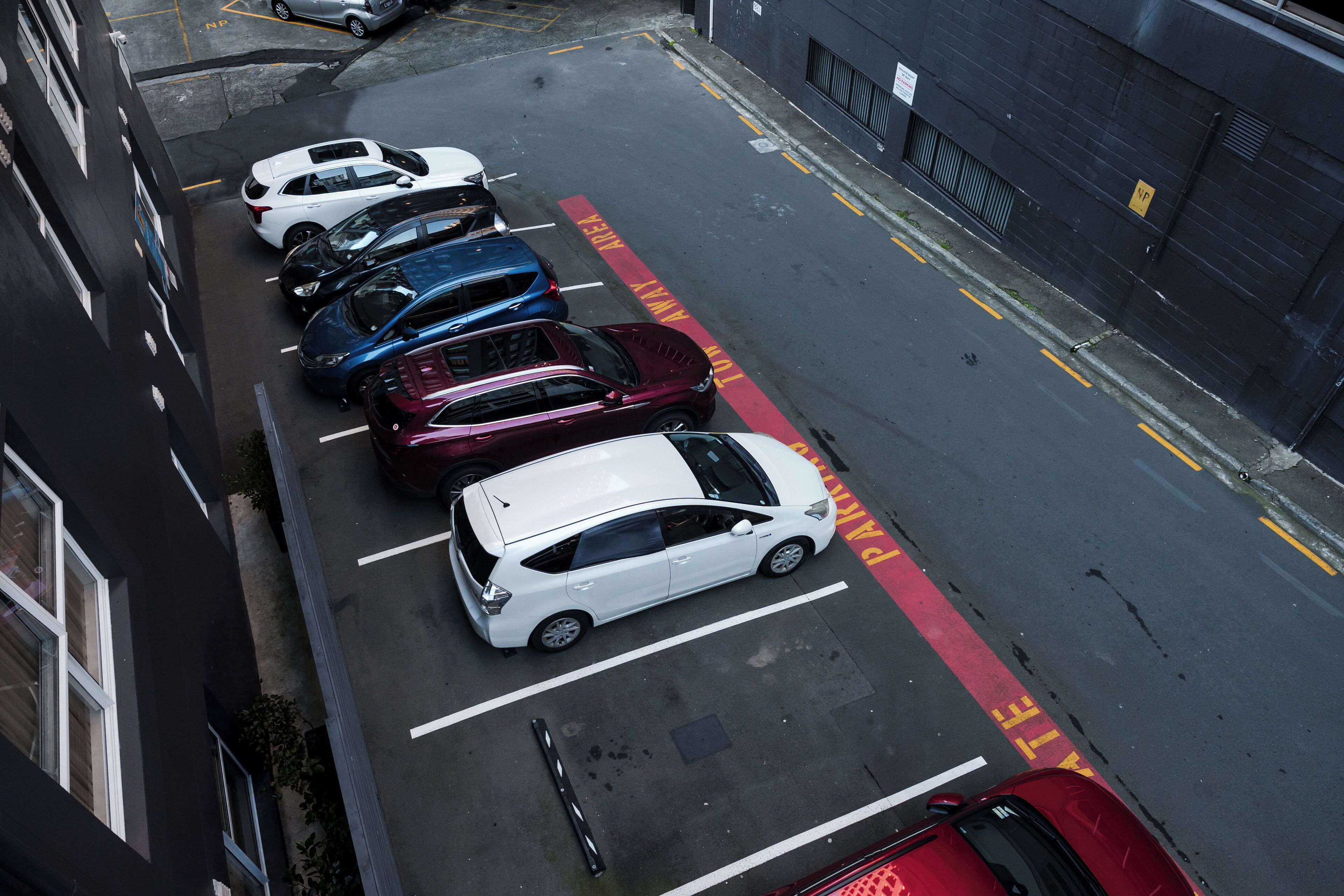 A parking lot with multiple cars parked in designated spaces.