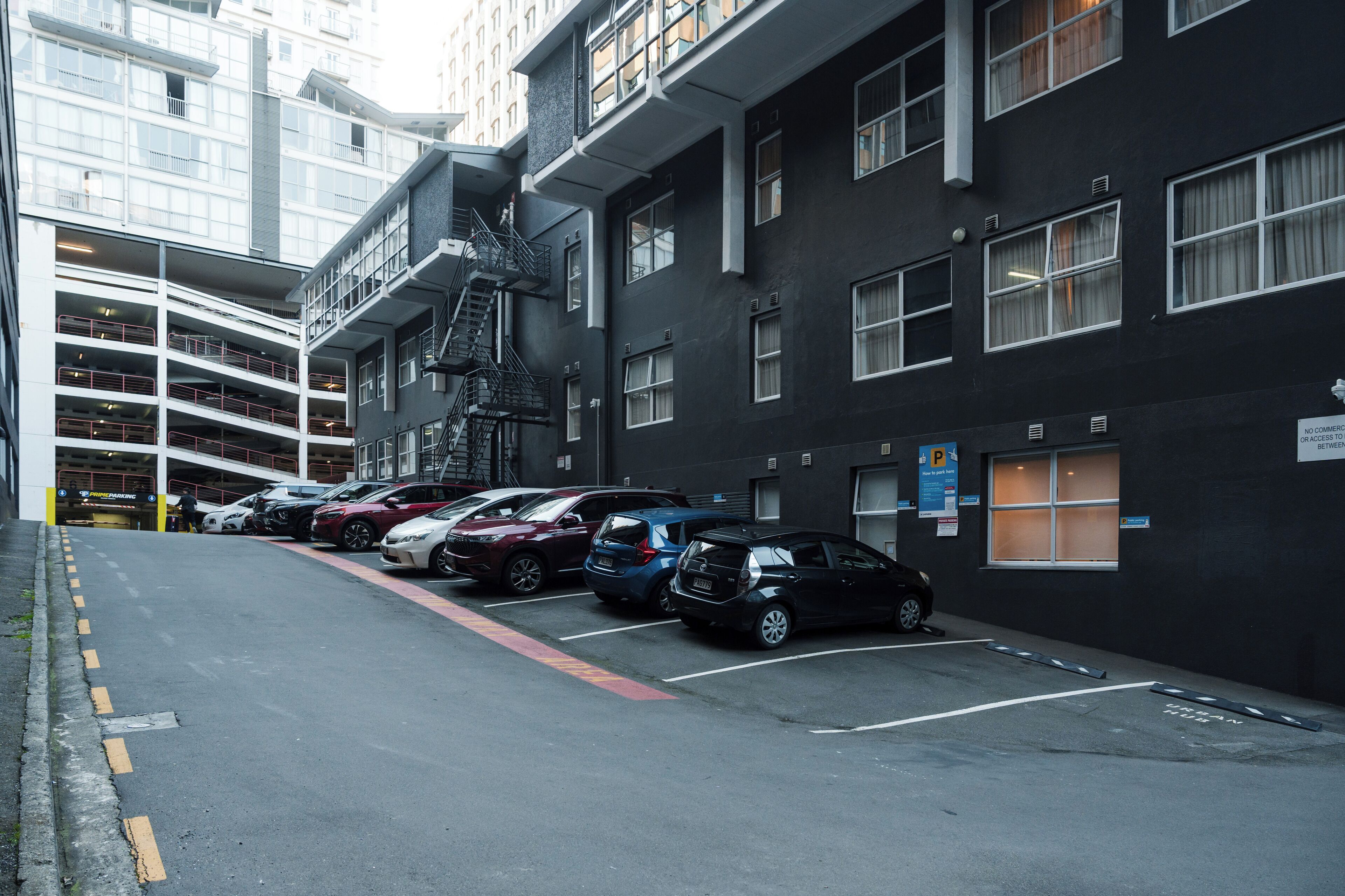 Un estacionamiento con varios niveles y una fila de coches aparcados.