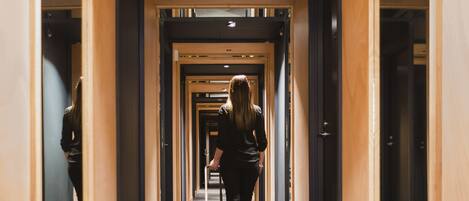 A hotel corridor with wooden paneling and a carpeted floor.