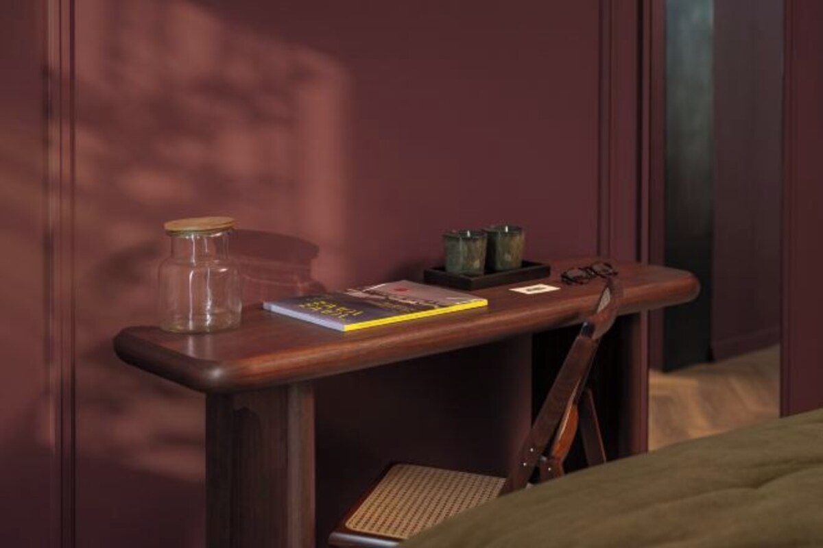 Een houten nachtkastje met een boek, een glazen pot en twee zoutstrooiers.