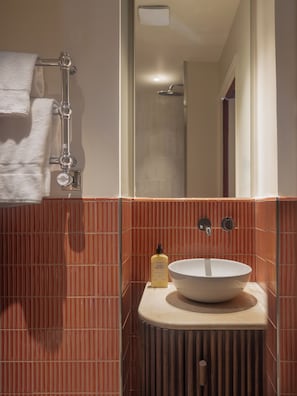 A bathroom with a white sink, a towel rack, and a shower. - Lazare Nomade (Paris)