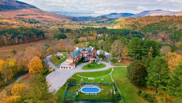 A large estate with a swimming pool, tennis court, and a well-maintained lawn.