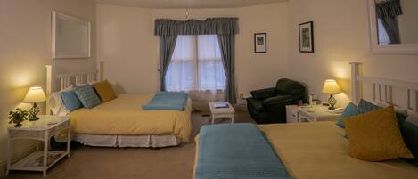 A bedroom with two beds, a ceiling fan, a window with curtains, and bedside lamps.