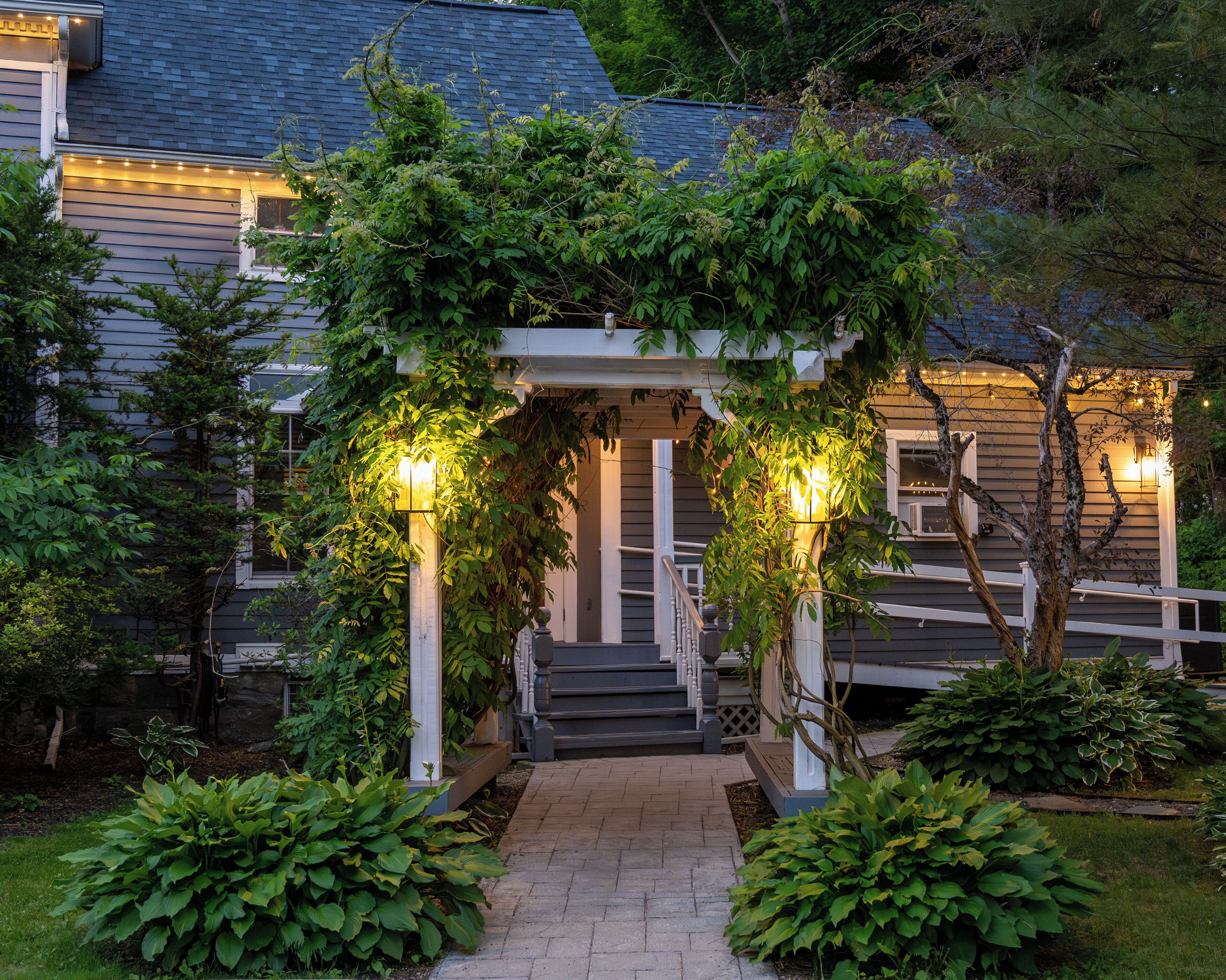 A house with a covered porch, steps leading up to it, and a pathway.