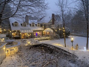 A snow-covered outdoor area with a patio, seating, and a covered dining area.