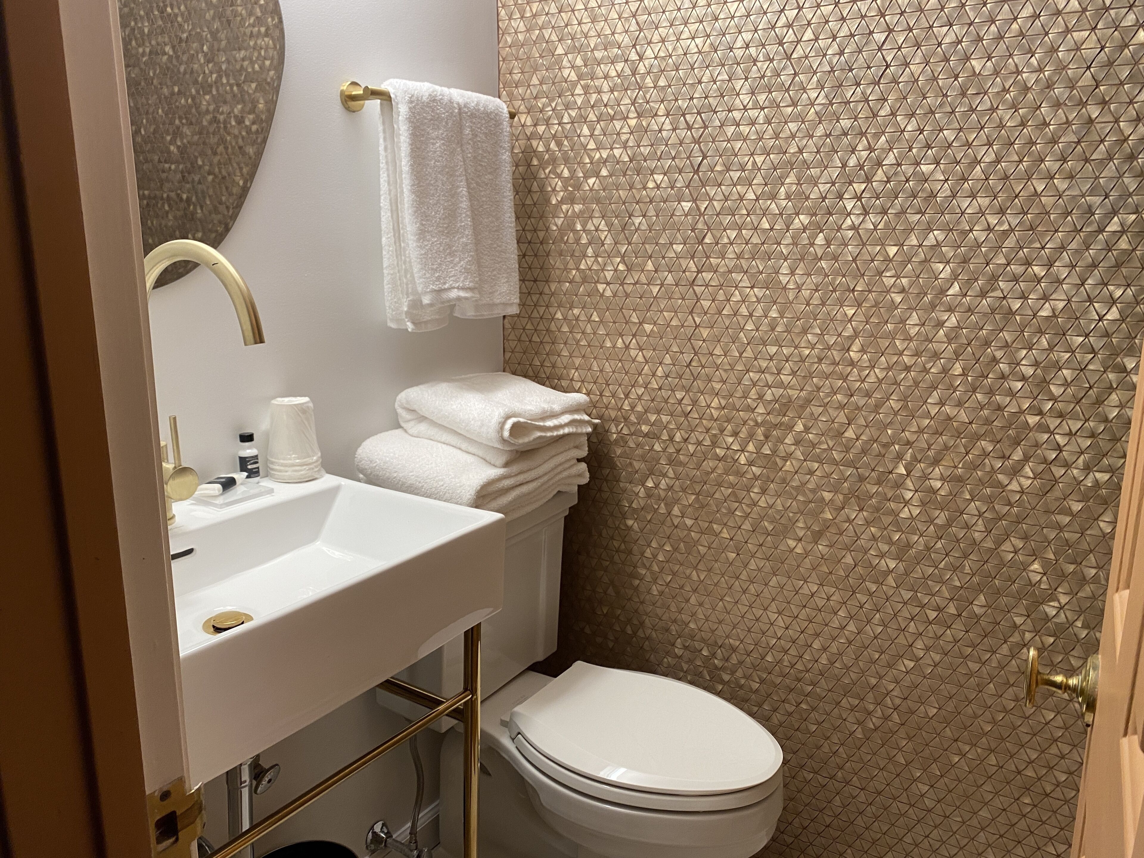 Un baño con un lavabo blanco, un inodoro y un perchero para toallas.