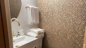 Un baño con un lavabo blanco, un inodoro y un perchero para toallas.