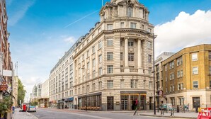 Un edificio histórico con una cúpula destacada y arquitectura clásica, situado en la intersección de calles.