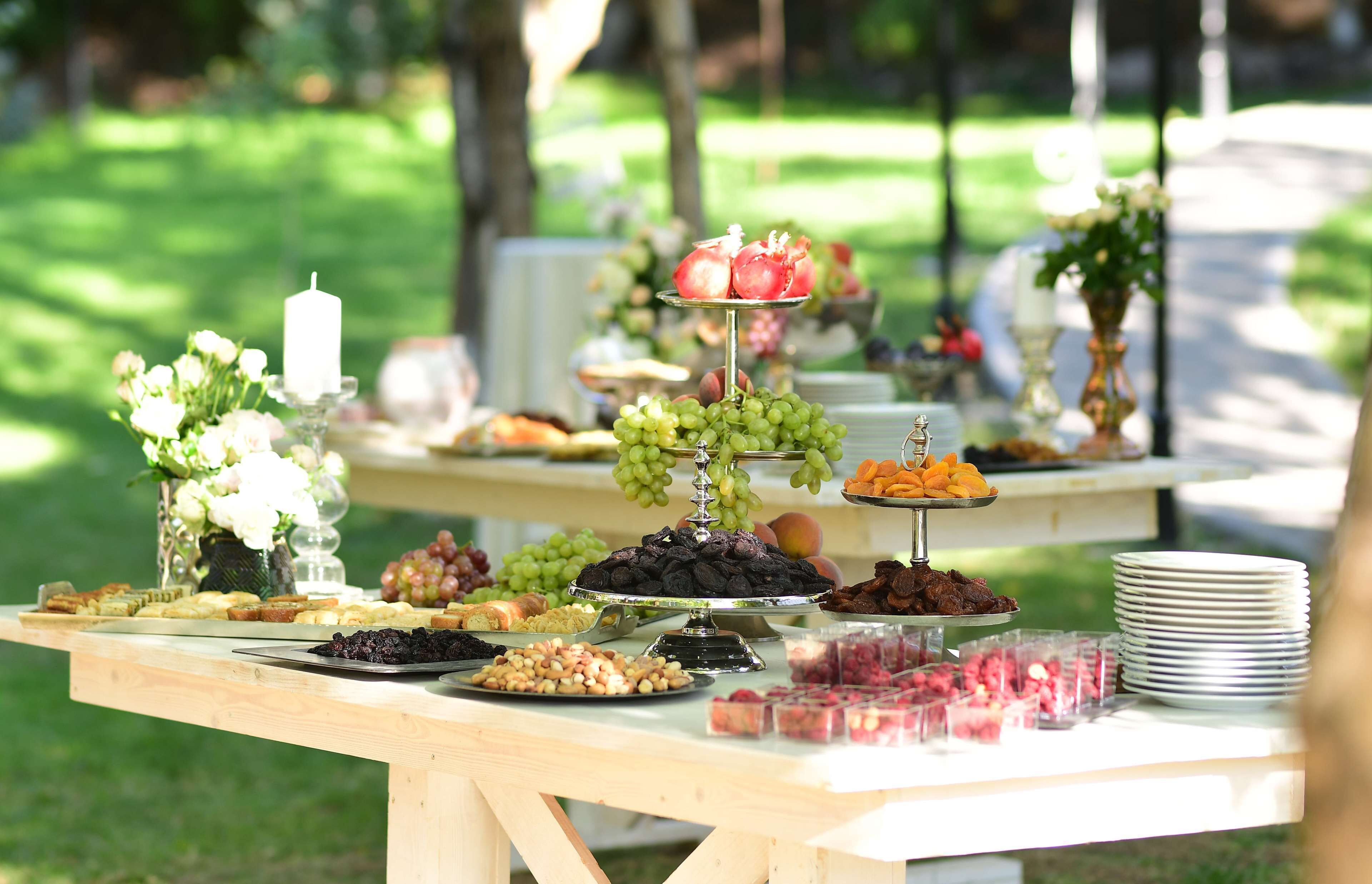 Una mesa de picnic con comida diversa y una vela.