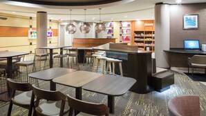 A modern restaurant with round tables, bar stools, and a counter. - SpringHill Suites by Marriott Indianapolis Fishers (Fishers)